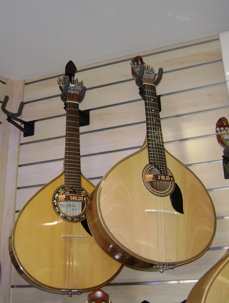 Two Portuguese guitars side by side, a Coimbra guitar on the left and a Lisbon guitar on the right, with pear-shaped bodies and ornate tuning heads